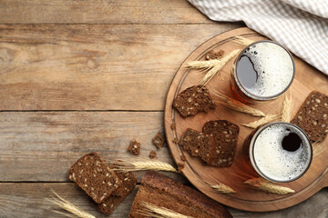 Delicious kvass, bread and spikes on wooden table, flat lay. Space for text