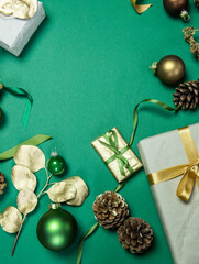 weihnachtliche Dekoration mit Geschenken, Zuckerstange, Geschenkband Zapfen, Sternen, Gräsern und Eukalyptus in gold auf grünem Untergrund