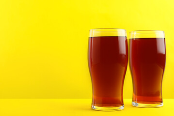 Delicious homemade kvass in glasses on yellow background. Space for text
