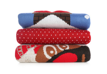 Stack of warm Christmas sweaters isolated on white