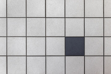 One black tile among many grays.