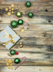 Sortiment für Weihnachten, Kugeln, Geschenk, Stern, Schnee in gold, grün und gelb auf rustikalem...