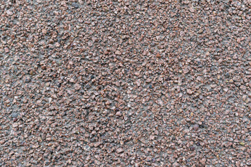 Small stone surface for the backdrop. Shades of black and brown. Abrasive surface concept.