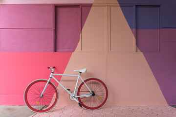 Bicycle with colorful (purple, blue pink and beige) wall as background