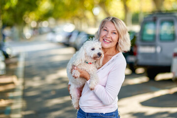 Elderly woman walking with a dog outdoors