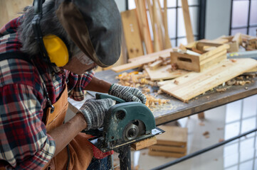 Carpenter working on wood craft using professional cutting tools for hand crafting at workshop to produce construction material or wooden furniture . DIY maker and carpentry work concept.