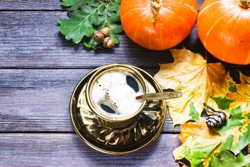 Autumn composition with cup of pumpkin latte with marshmallow,  leaves and pumpkin on wooden background.copy space, flat lay.