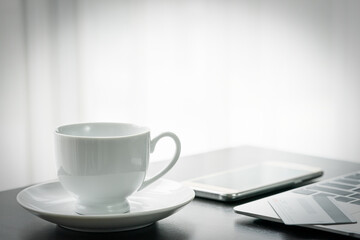 Coffee cup and laptop on deck