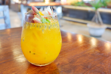 Passion fruits half and juice with leaves on the vintage wooden background. Closeup, Select focus.Passion fruit ice in glass on wood table.Close up.