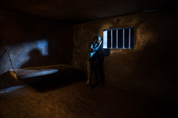 Jail or prison cell. Man in prison man behind bars concept. Old dirty grunge prison miniature. Dark prison interior creative decoration. Selective focus