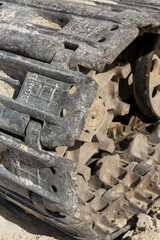 A close-up of the tracks of a heavy large excavator in a mining quarry.