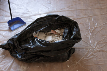 Construction garbage after apartment repair in a black plastic bag. Cleaning after renovation work....