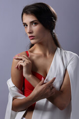 Naklejka premium Portrait of a beautiful girl in a red bustier and a white Cape