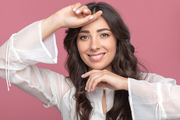 Fototapeta premium Portrait of a beautiful brunette girl with beautiful makeup and healthy clean skin. She's wearing a white summer dress. Makeup concept.