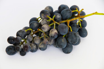 Black grapes, large fresh fruits with green leaves on a white background. Sick grapes