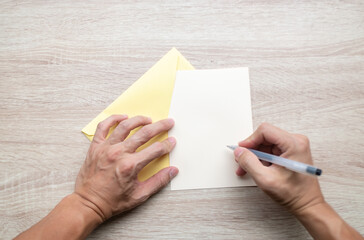 Obraz premium Male hands writing Empty cards on wooden table.