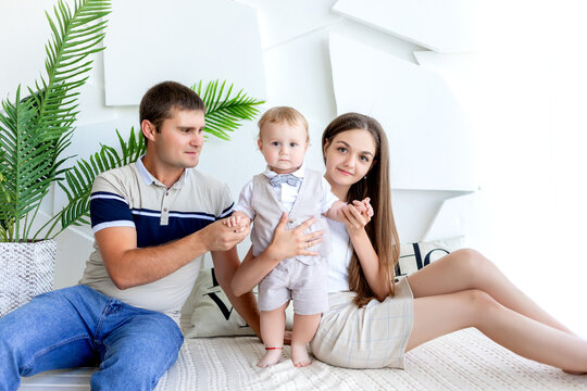young mom and dad holding a child, parents with a child in a photo Studio, family day, happy family