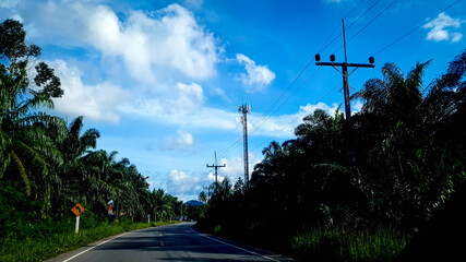 road with electric pole along the road on blue sky with the clouds background.