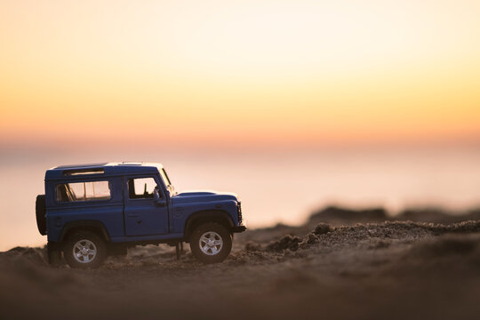Close up shot of a Land Rover SUV vehicle on sand and on sunset.
