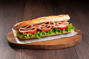 A turkey sandwich with tomato and lettuce