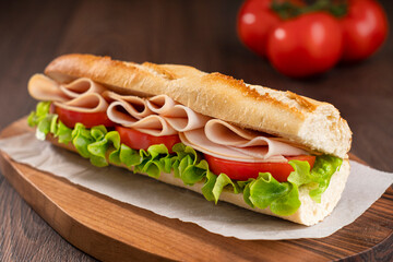 A turkey sandwich with tomato and lettuce