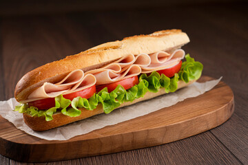 A turkey sandwich with tomato and lettuce