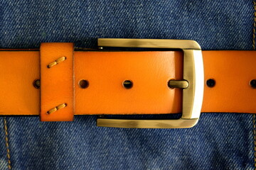 Leather belt and blue jeans. Waist accessory. Fashionable leather belt and jeans.