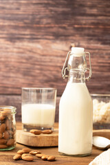 Almond milk. Healthy homemade, blended almond milk bottle with glass of fresh milk. Rustic background.