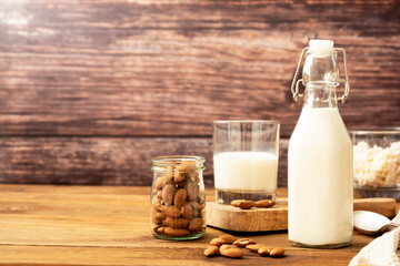 Almond milk. Healthy homemade, blended almond milk bottle with glass of fresh milk. Rustic background. Copy space.