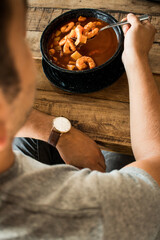 Hombre comiendo caldo de camarón 