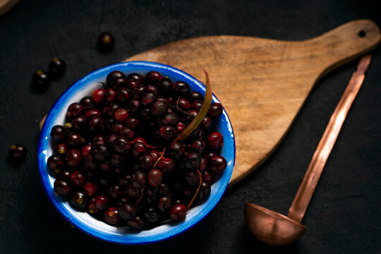 vista cenital de FRUTA DE COROZO EN UN plato azul Y UN CUCHARON  SOBRE UNA TABLA DE MADERA  Y UN FONDO DE MADERA