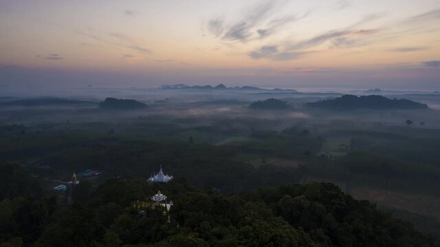 4K time-lapse view of Buddhism temple Thamma Park padoga on hill at sunrise in Ban Khao Na Nai village in Phanom, Surat Thani, Thailand	