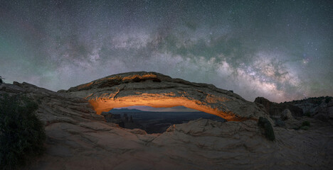 Fototapeta na wymiar Mesa Arch lit up at night with Milky Way Galaxy above