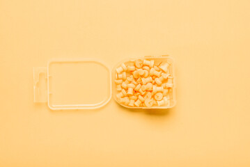 Yellow push pins on yellow background in box