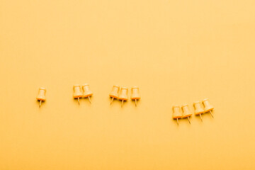 Set of 4 yellow push pins on yellow background