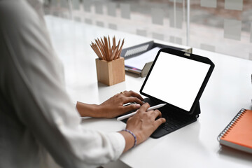 Cropped shot woman typing mockup tablet computer with blank screen..