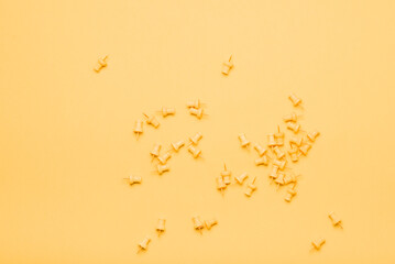 Yellow push pins on yellow background in box