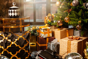 Close-up of a Christmas tree decorated with gold balls. Under the Christmas tree a large number of Christmas gifts. Christmas holiday concept