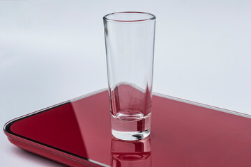 daylight. glass on a burgundy background. Reflection in the shadow. Copy space. text.