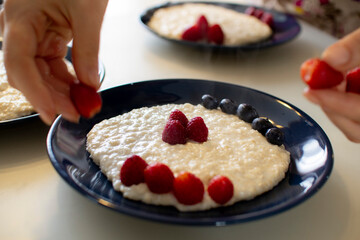 Oatmeal porridge with berries, in a blue plate. Healthy breakfast.