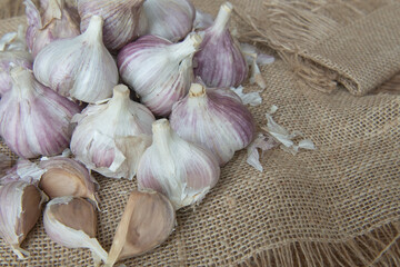 A pile of fresh garlic bulbs and cloves on the wooden background