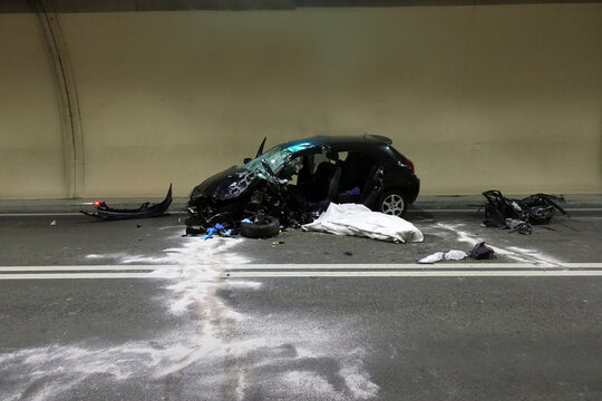 Car crash accident with deadly motorist in frontal collision between two cars on the road.  Fatal car accident in the night inside a highway gallery.