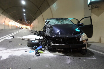 Car crash accident with deadly motorist in frontal collision between two cars on the road.  Fatal car accident in the night inside a highway gallery.