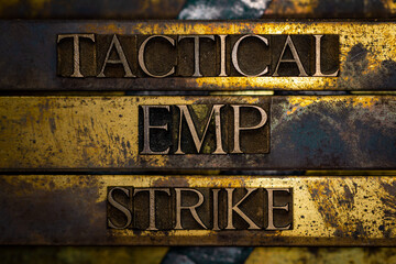 Tactical EMP Strike text formed by real authentic typeset letters with barbed wire on vintage textured grunge copper and gold background