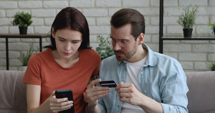 Young couple try to pay use cellphone and card having problems with online payment processing feels worried. Fraud and scam, insufficient funds, lack of money, unable impossible of transaction concept