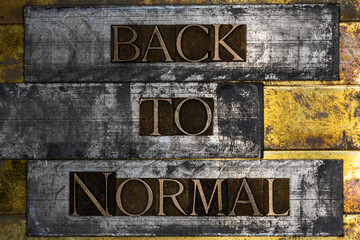 Back to Normal text formed by real authentic typeset letters on vintage textured grunge copper and...