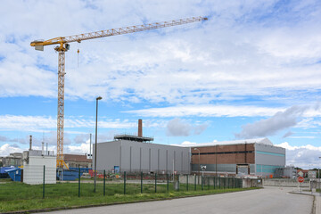 Obraz premium Construction site with crane at the interim storage facility of the former nuclear power plant in Lubmin near Greifswald in Germany, blue sky with clouds and copy space