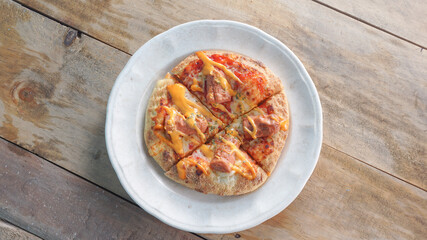 Delicious small pizza on wooden background