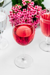 Pink drink in a glass. Pink flowers.