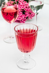 Pink drink in a glass. Pink flowers.